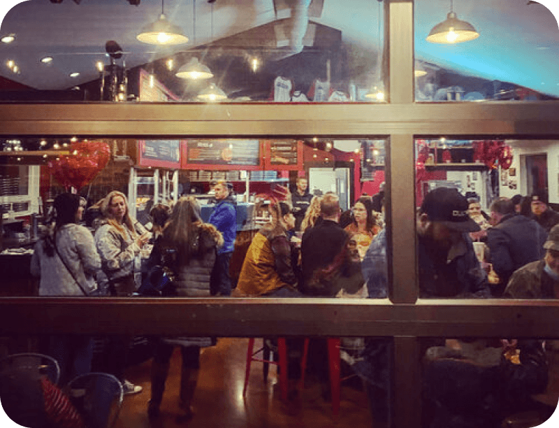 Guests at Fat Zach's pizza restaurant looking through a window