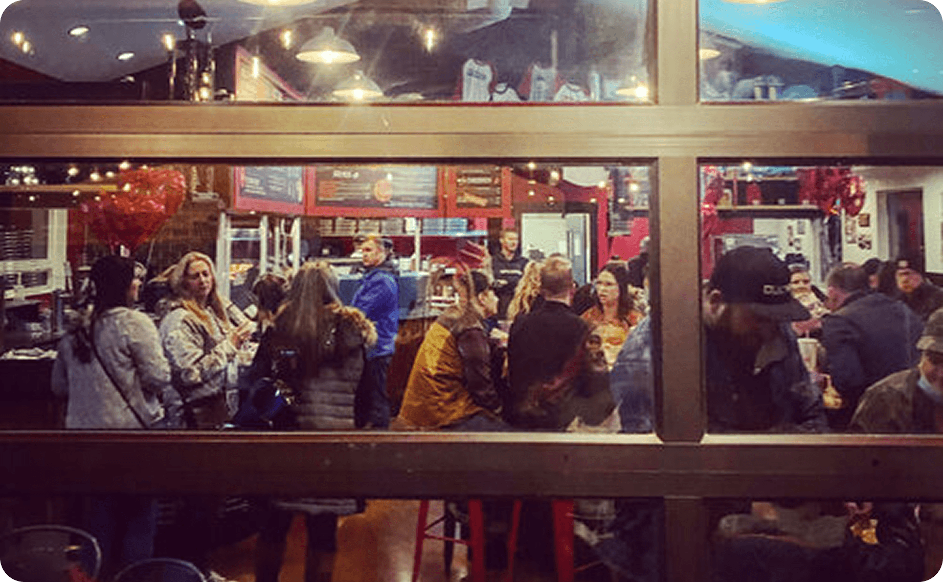 Guests at Fat Zach's pizza restaurant looking through a window