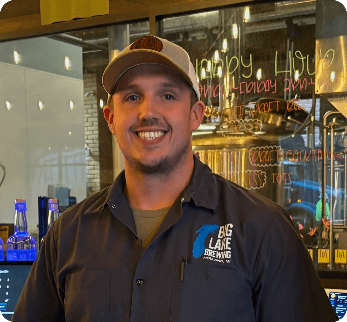 Mike Jones, General Manager of Big Lake Brewing, smiling behind the bar