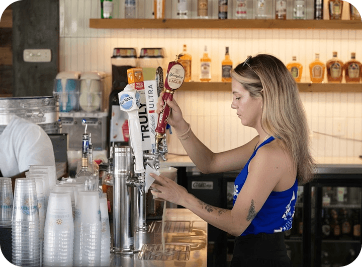 Un bartender sirve una cerveza de barril en The Mudpuppy