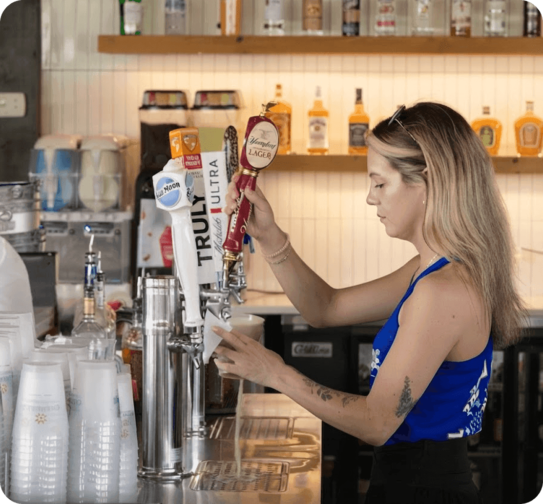 Un bartender sirve una cerveza de barril en The Mudpuppy