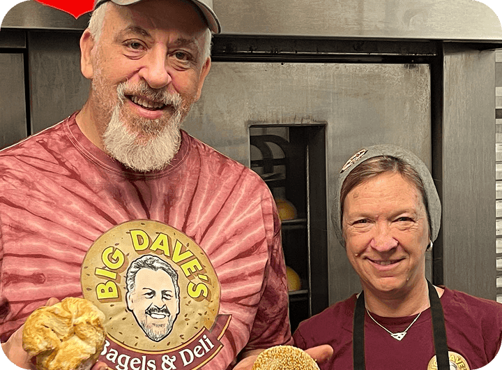 Big Dave’s Bagels & Deli owners smiling and holding fresh bagels
