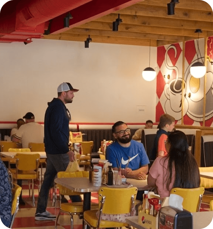 Un mesero conversa con comensales en Breakfast Brothers