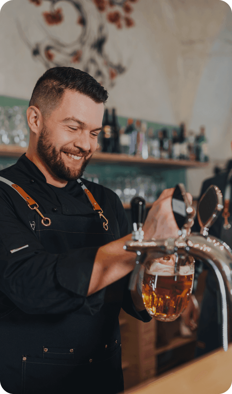 Brewery staff pouring beers while guests enjoy a busy taproom