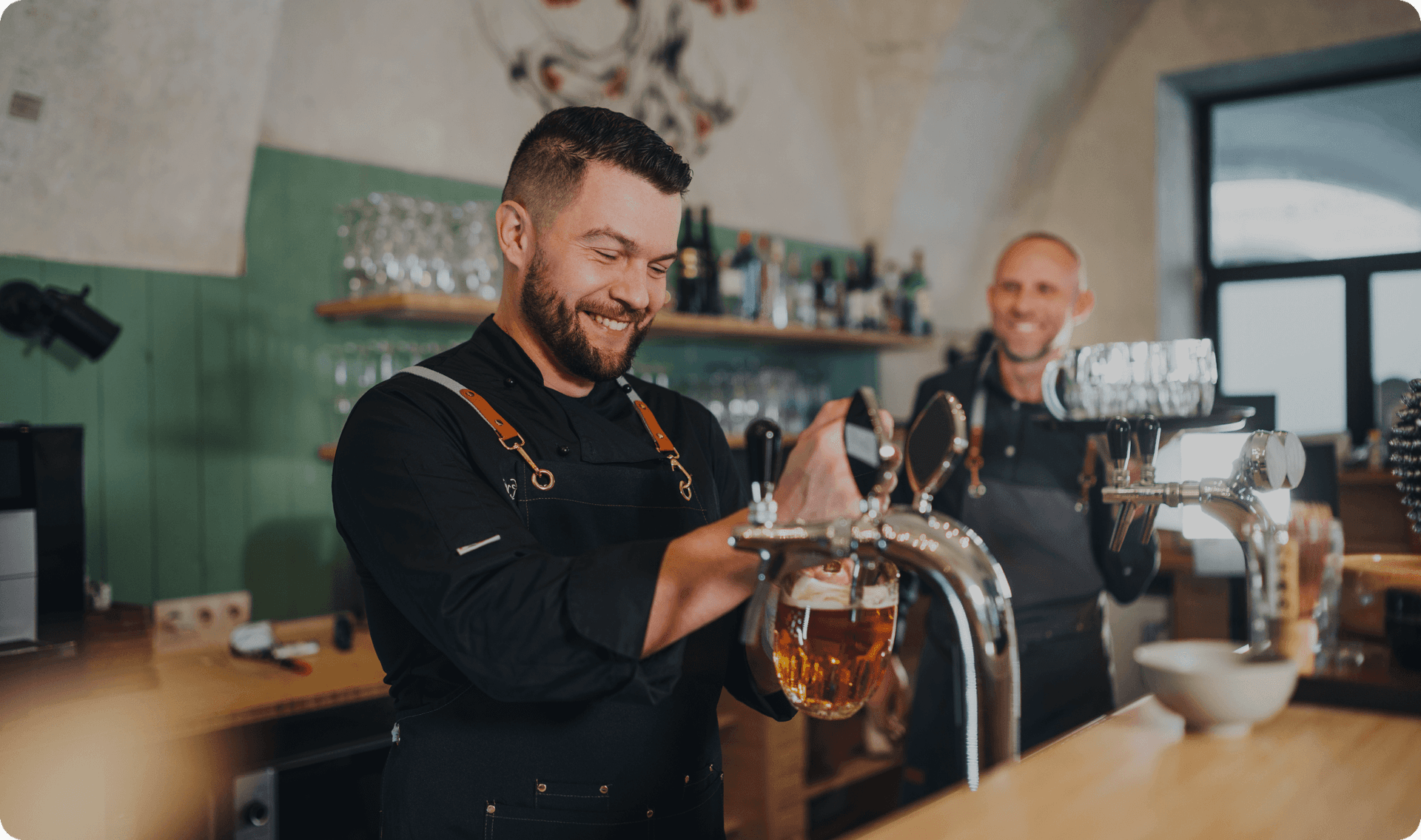 Brewery staff pouring beers while guests enjoy a busy taproom