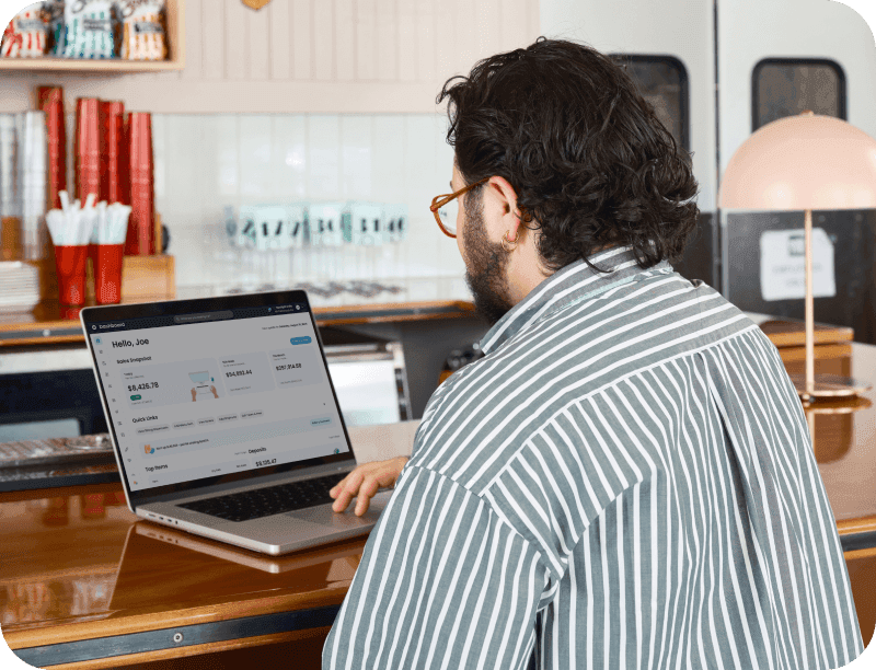 Manager looking at SpotOn reporting on a computer in a casual dining restaurant.