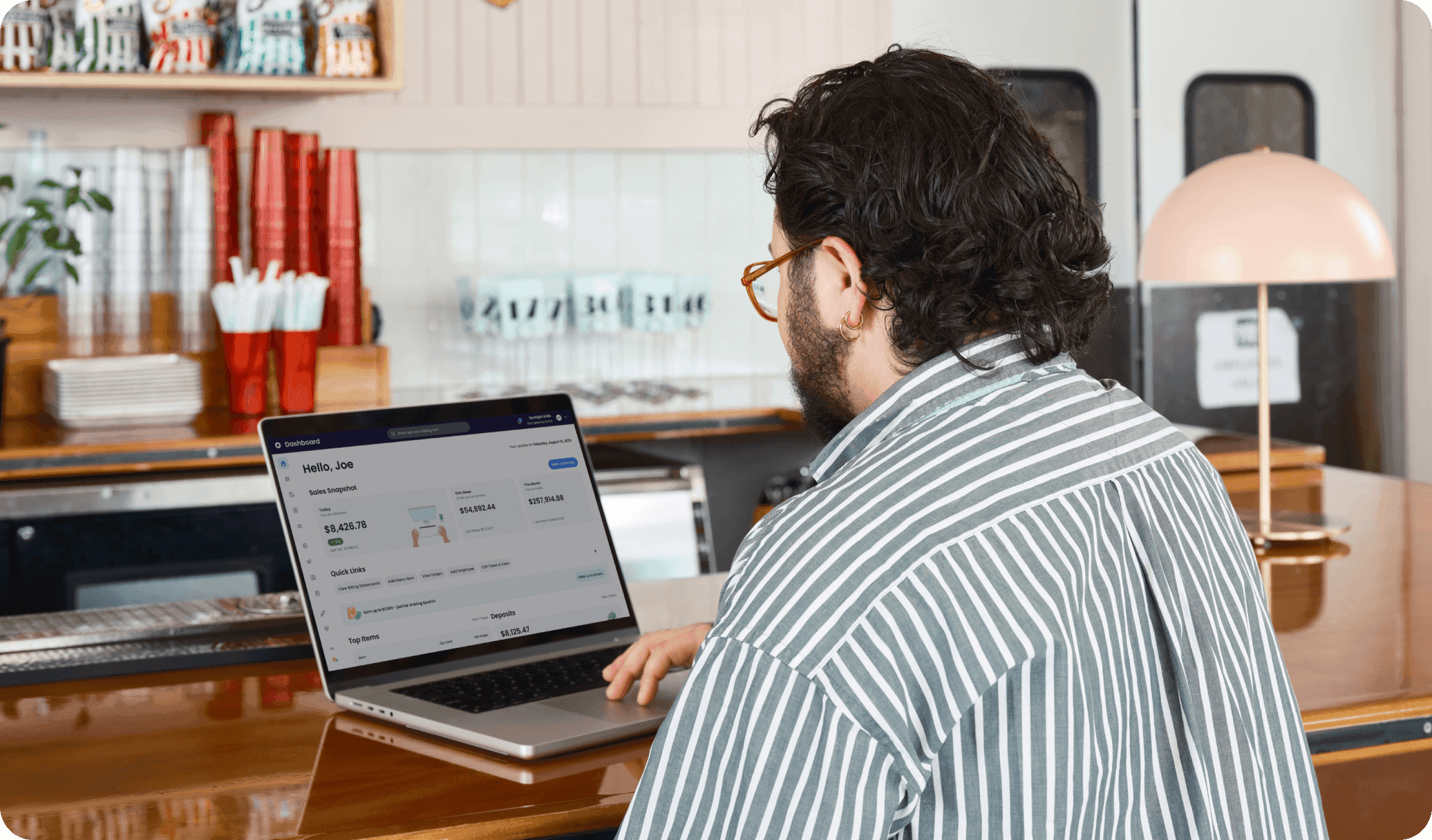 Manager looking at SpotOn reporting on a computer in a casual dining restaurant.