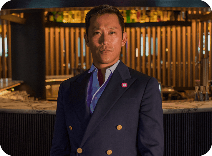 COTE Korean Steakhouse Executive Director in a navy blazer standing in front of a restaurant bar.