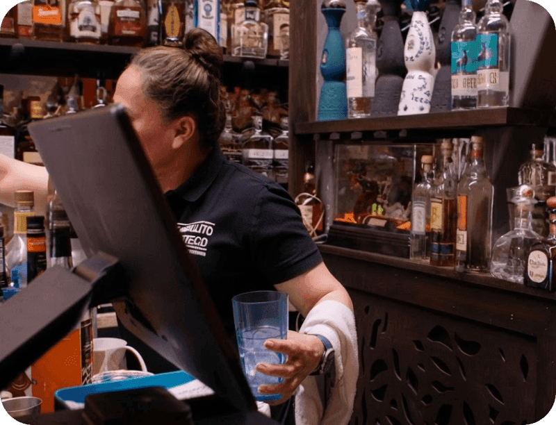 An employee using the POS at the counter in El Castillito restaurant