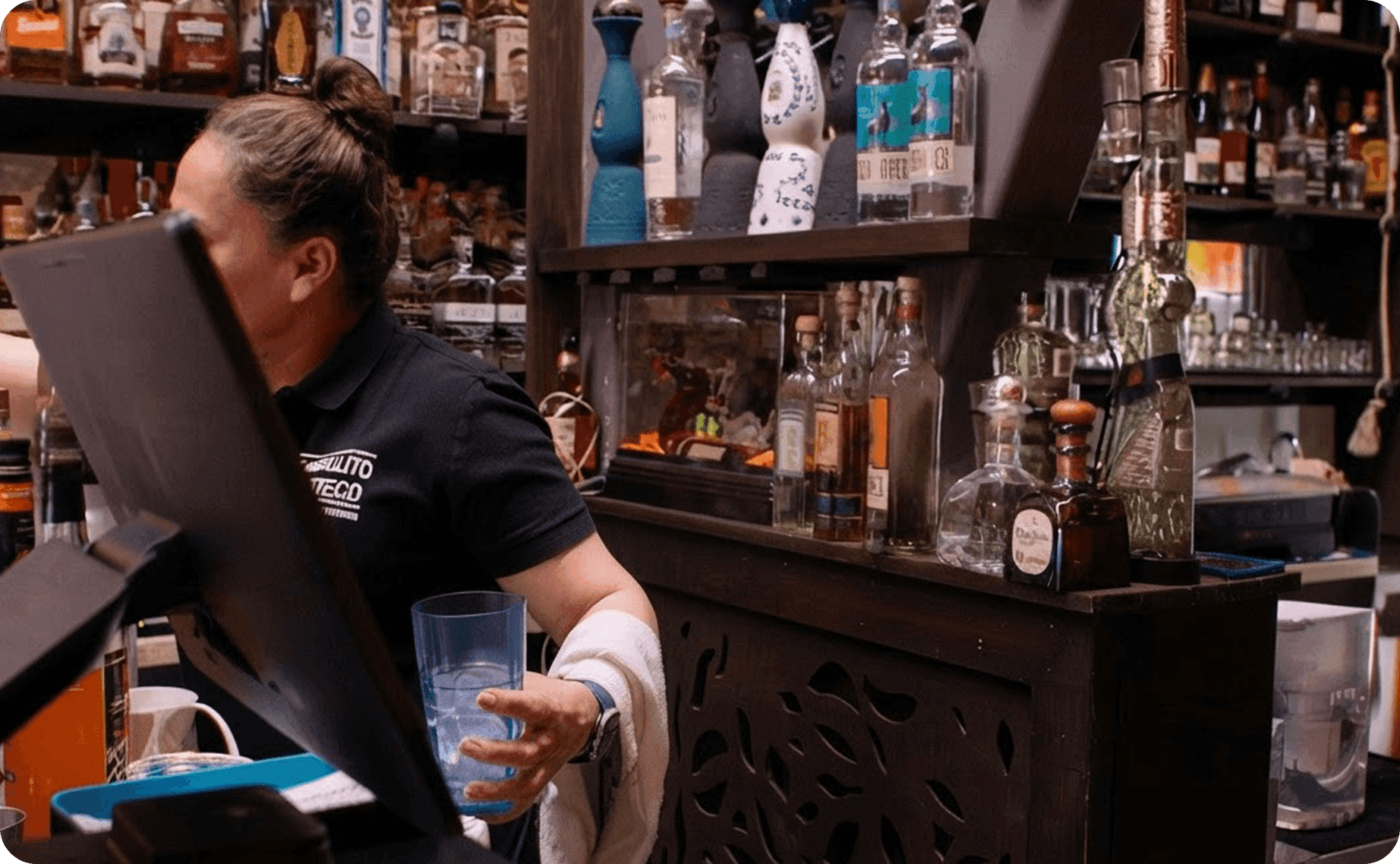 An employee using the POS at the counter in El Castillito restaurant