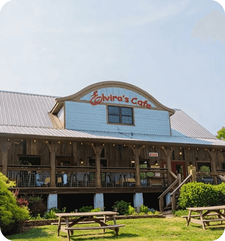 Exterior of Elvira’s Café, with a covered porch and picnic tables on the lawn