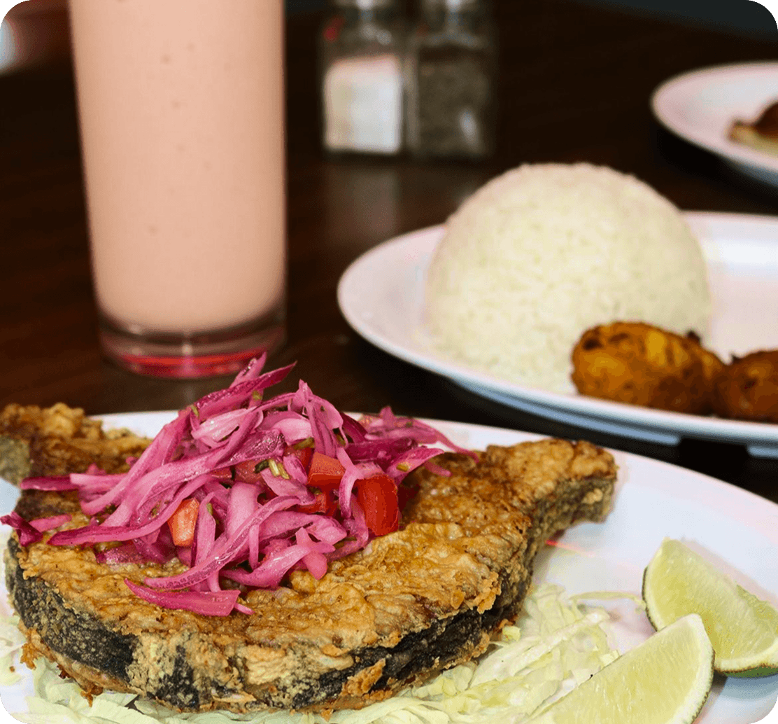 Fried fish with pickled onions, rice, and tostones at Cacique Restaurant