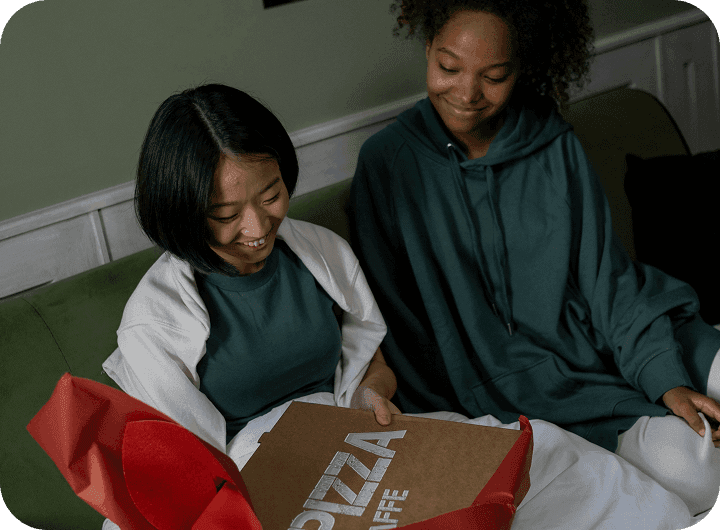 Guests sit around a table eating takeout from their favorite restaurant