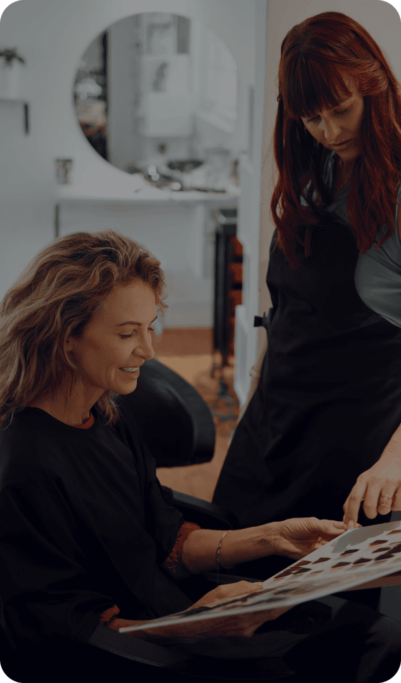 A hair salon worker works with a customer