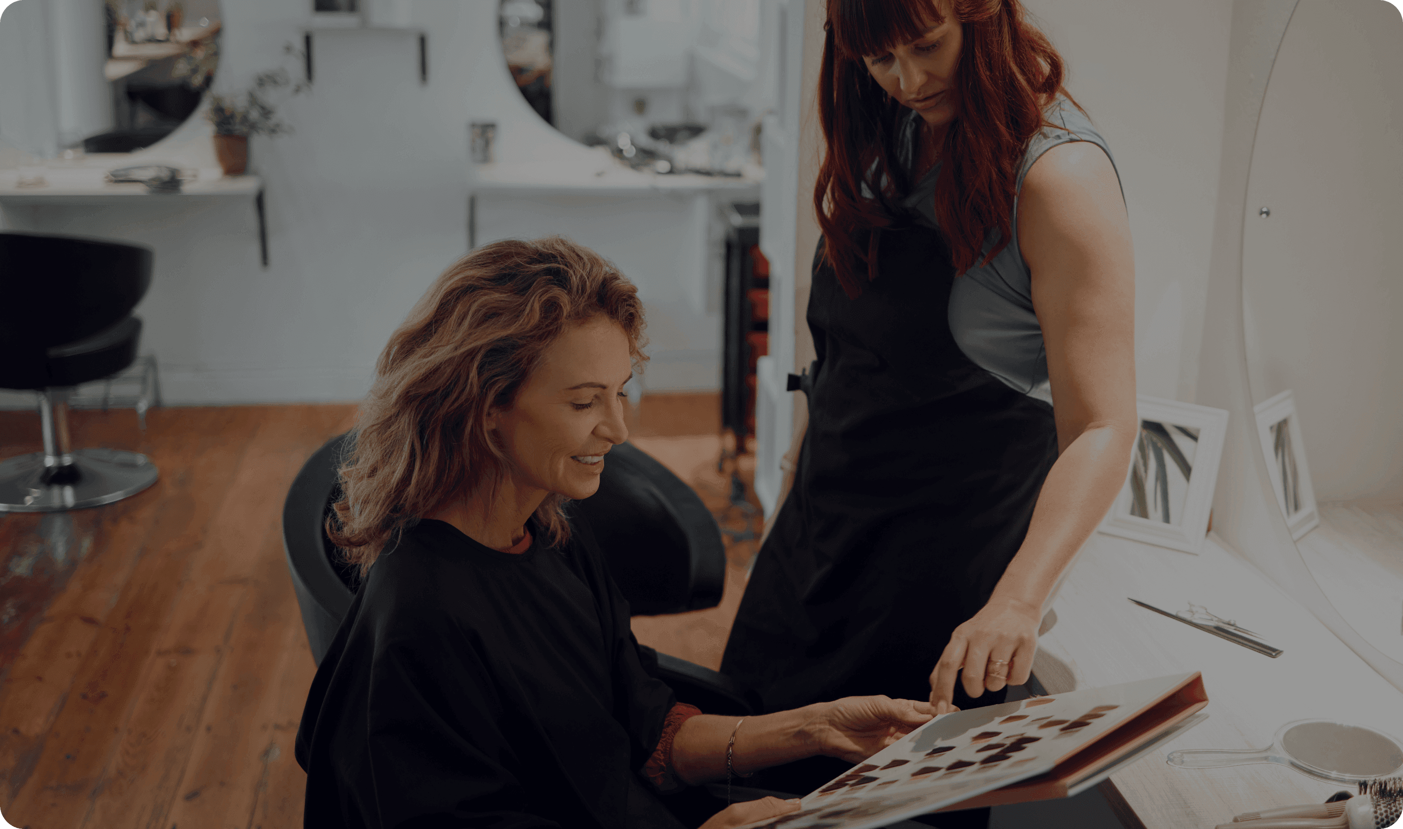 A hair salon worker works with a customer