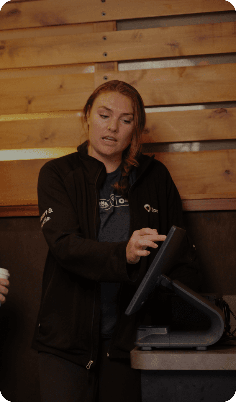 A SpotOn onboarding specialist setting up a sleek POS system for a busy, brand-new restaurant.