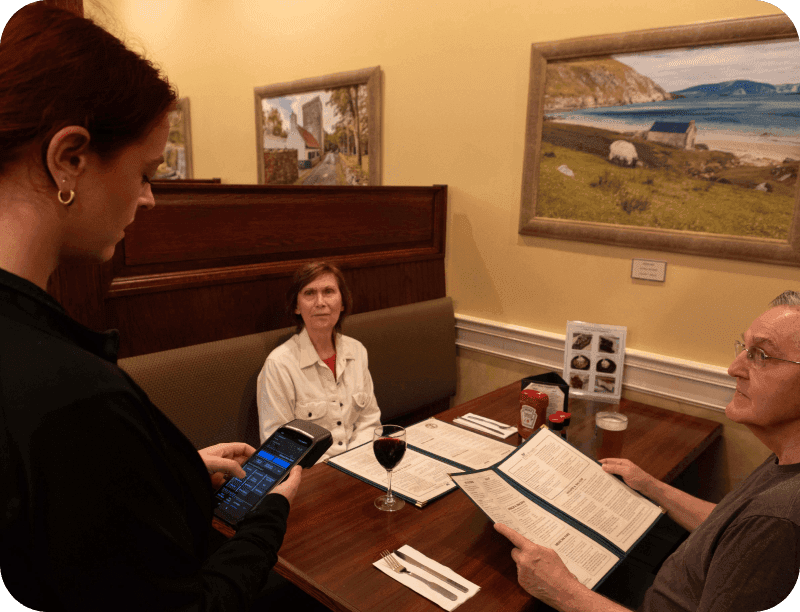 A server takes a table’s order with a SpotOn Handheld at J.P. Fitzgerald’s