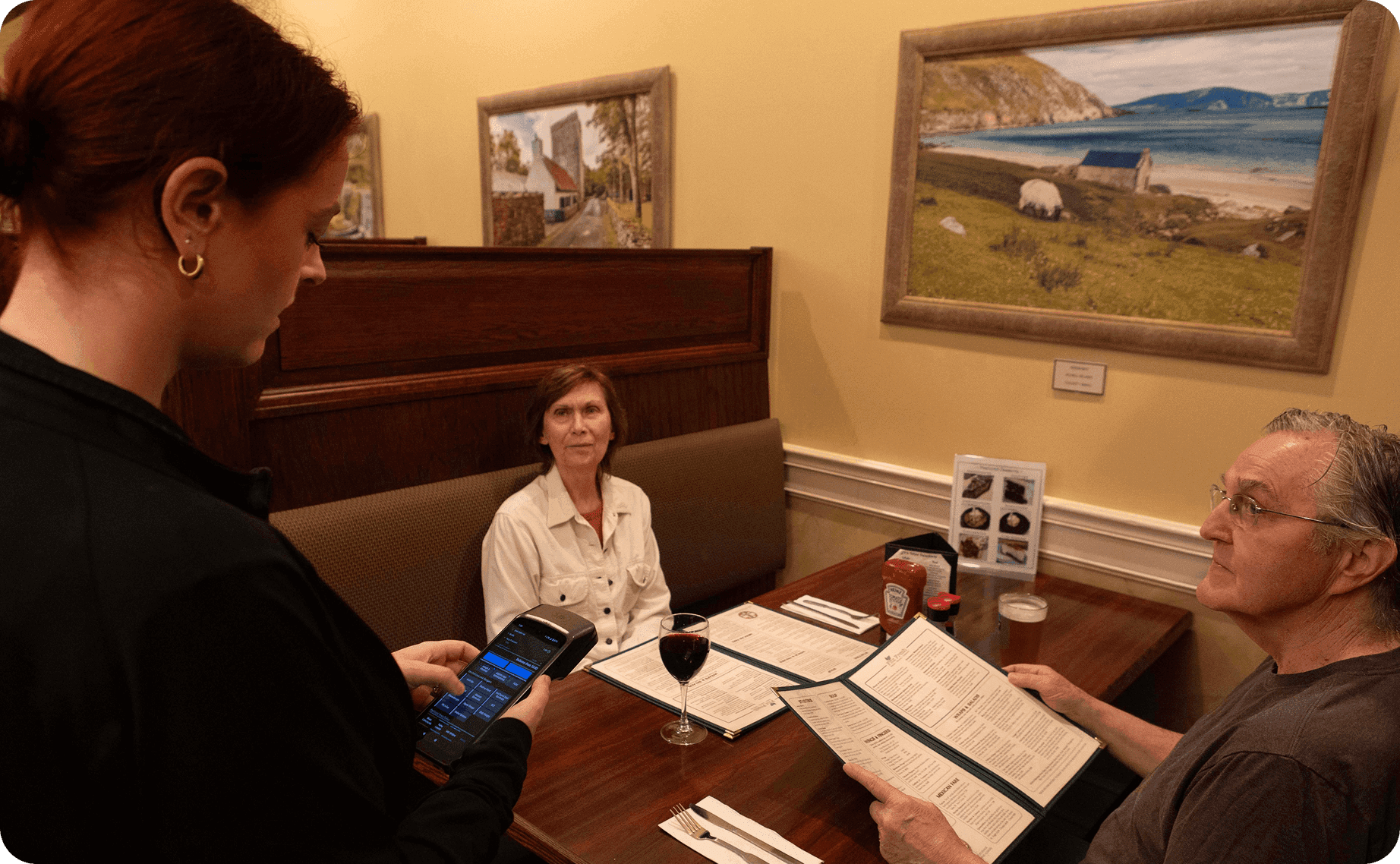A server takes a table’s order with a SpotOn Handheld at J.P. Fitzgerald’s