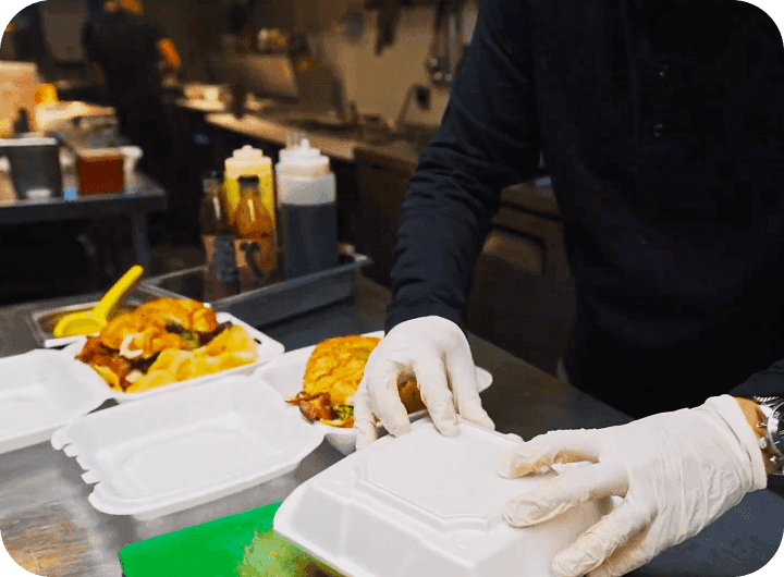 A cook boxes up an order at Urban Roast