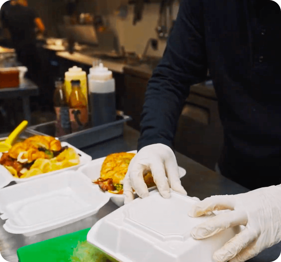 A cook boxes up an order at Urban Roast