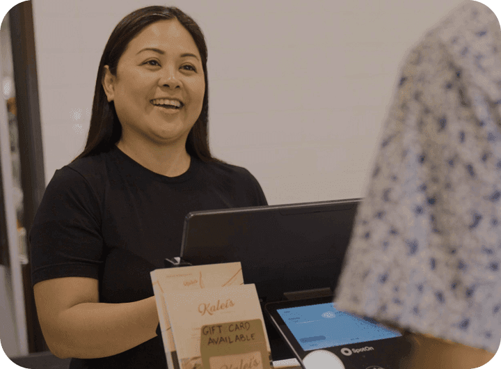 Smiling restaurant owner standing serving customers at her restaurant