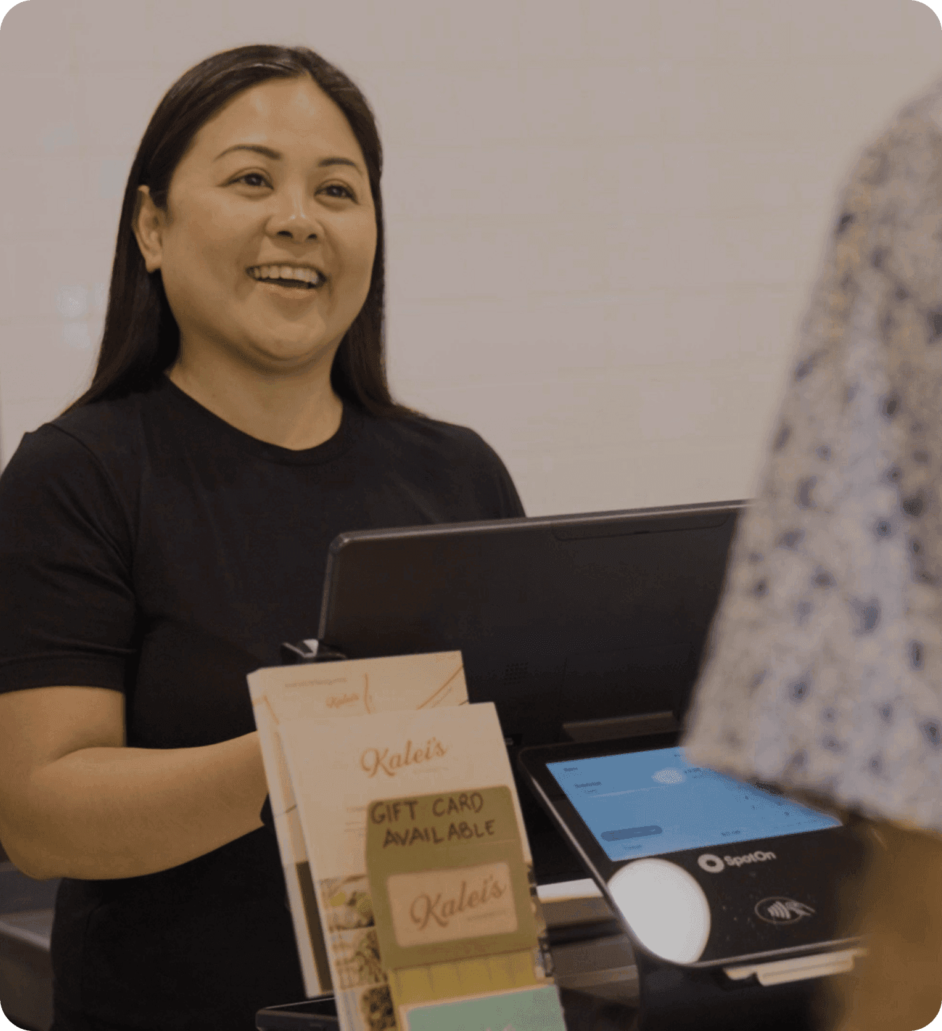 Smiling restaurant owner standing serving customers at her restaurant
