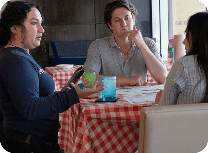 Mariah Booth using a SpotOn Handheld to take an order tableside at Hazel’s