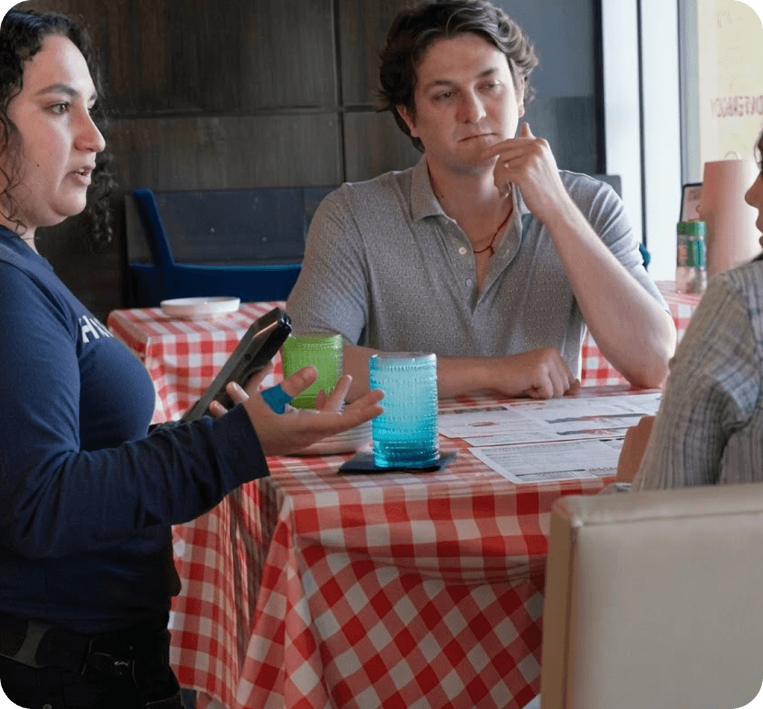 Mariah Booth using a SpotOn Handheld to take an order tableside at Hazel’s