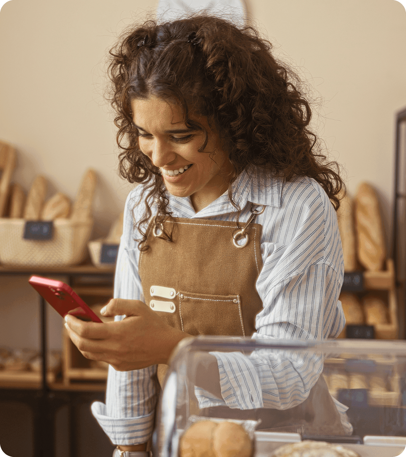 A small business worker uses their phone to take a payment at a farmer’s market