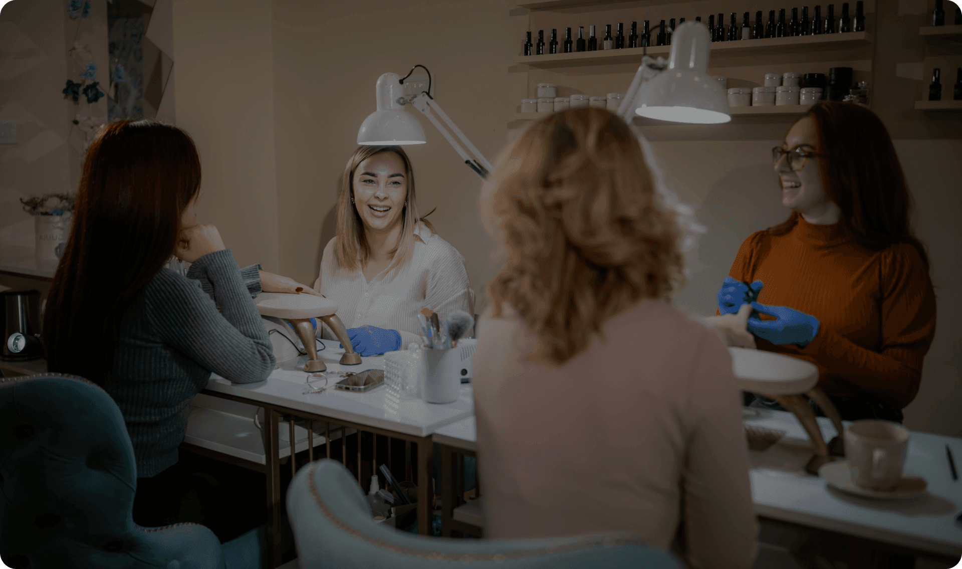 A nail salon worker works with a customer