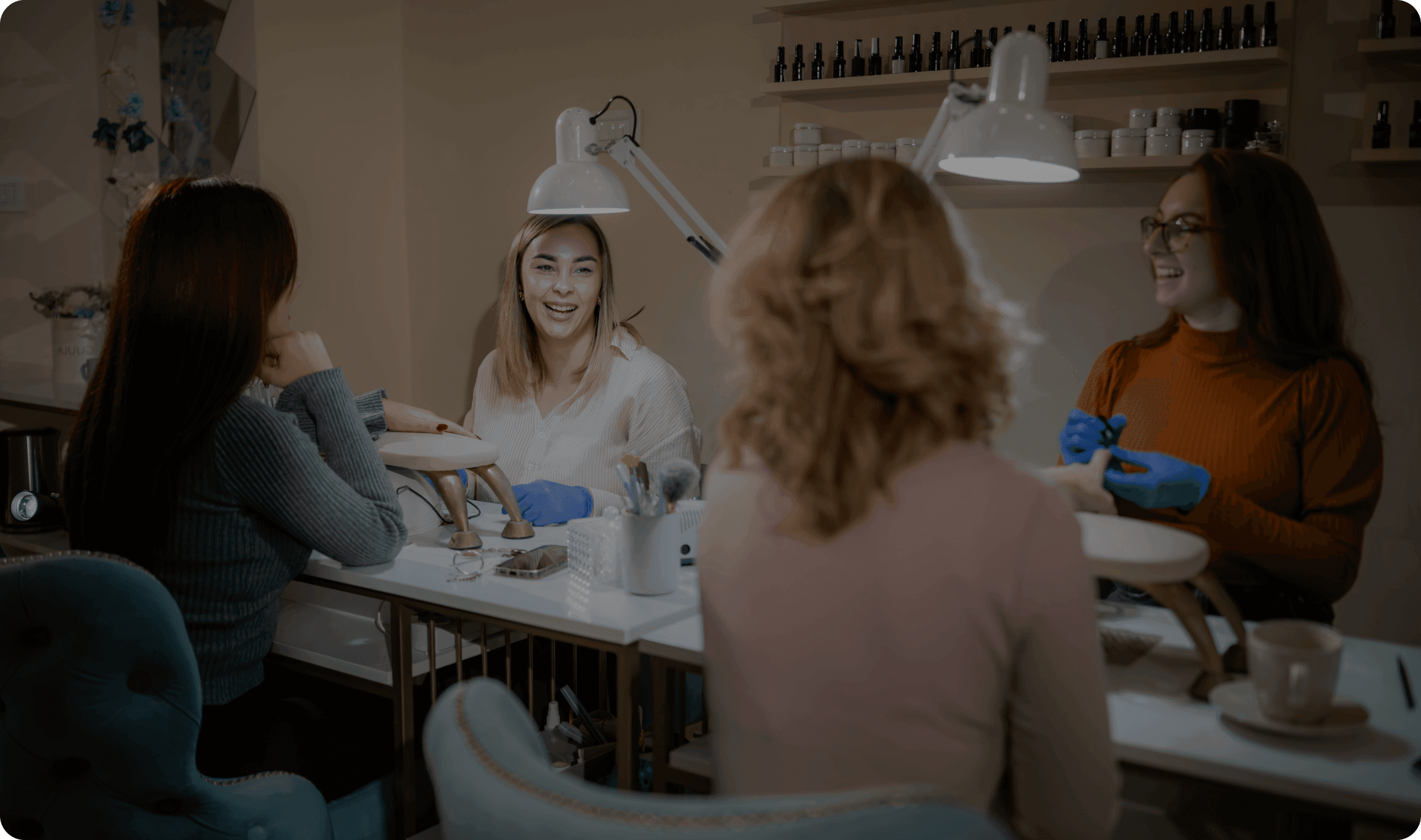 A nail salon worker works with a customer