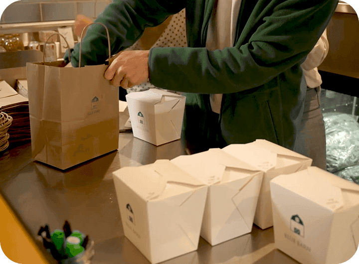 An employee bagging online to-go orders at Blue Barn