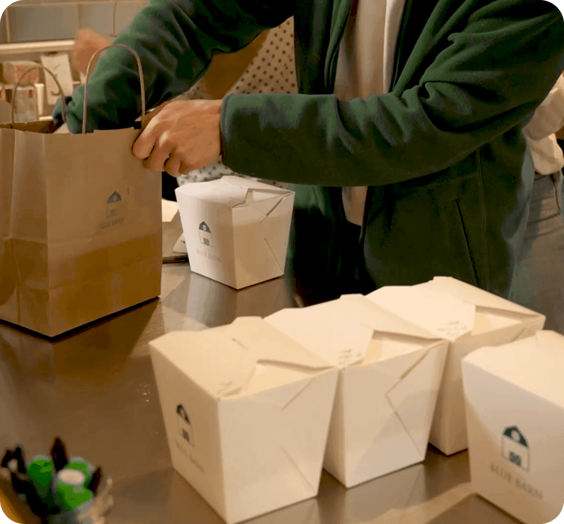 An employee bagging online to-go orders at Blue Barn