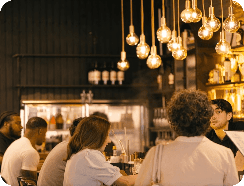 Guests seated at the bar at Port Union as a bartender takes their orders