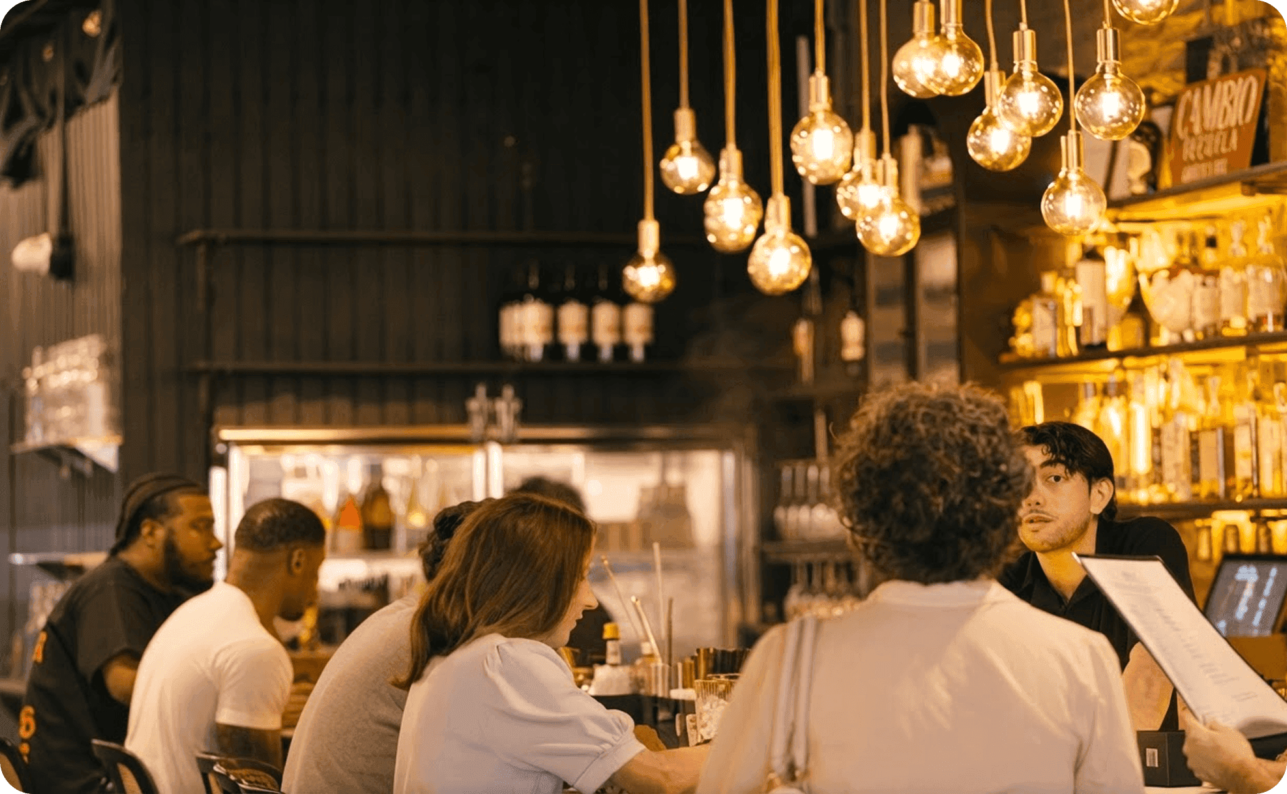 Guests seated at the bar at Port Union as a bartender takes their orders
