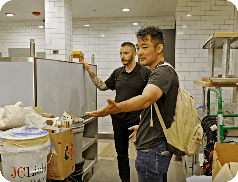 A restaurant owner observes construction work as they improve their business with funds from a restaurant loan
