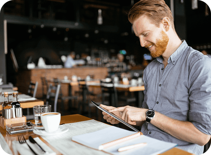Restaurant manager at a table using and iPad