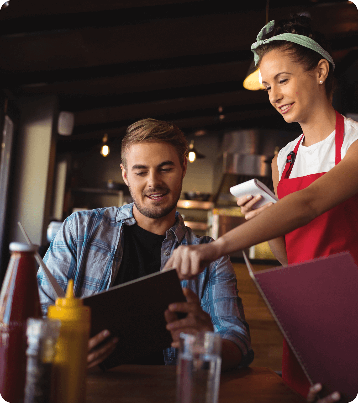 A restaurant server takes an order from a table of guests