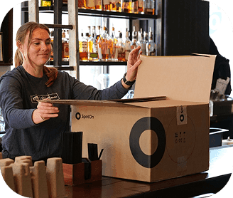 SpotOn employee unpacking SpotOn POS equipment at the bar