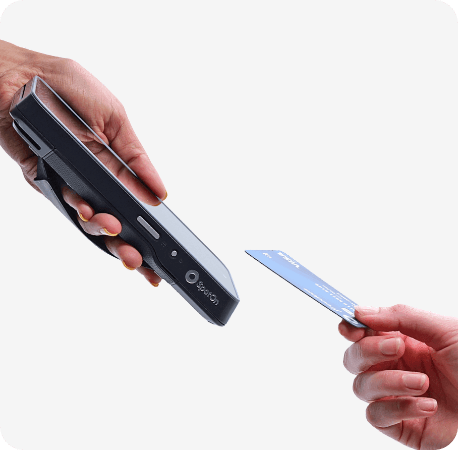 A hand holding SpotOn Handheld and another hand holding a card near the reader in a studio