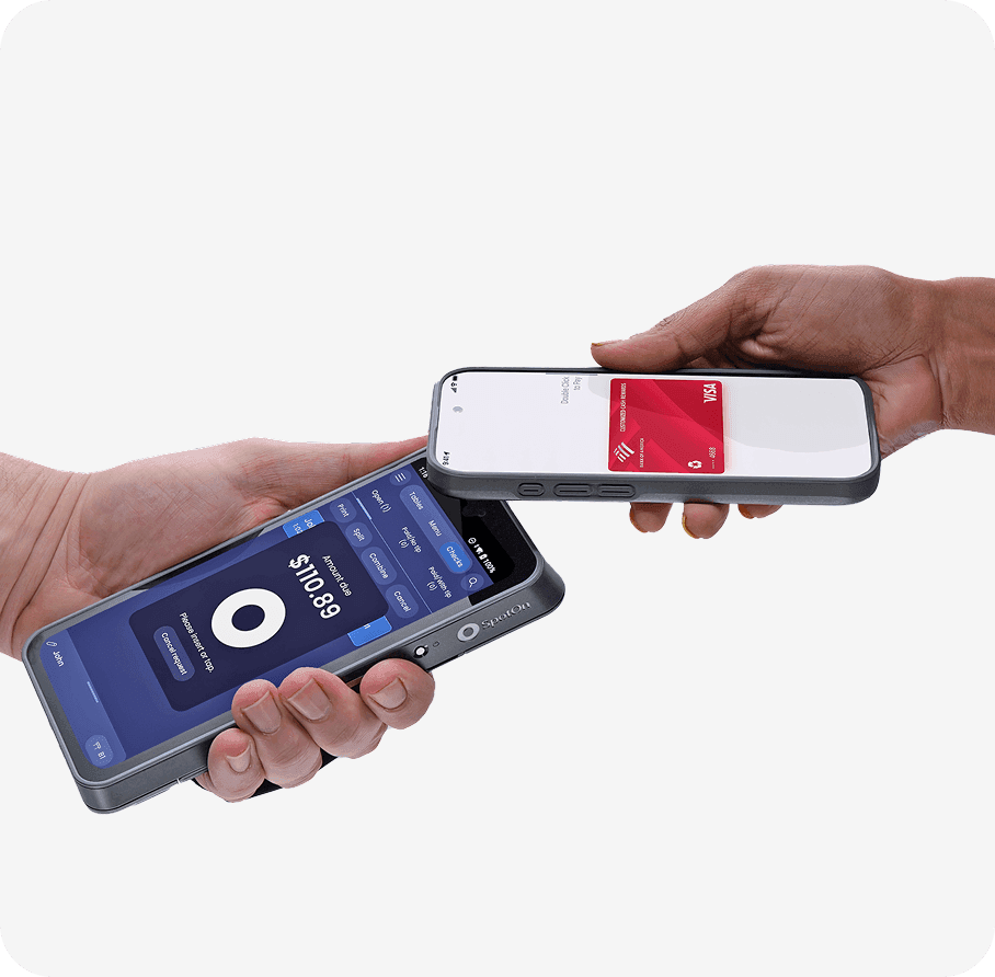 A hand holding SpotOn Handheld and another hand holding a smartphone near the reader in a studio