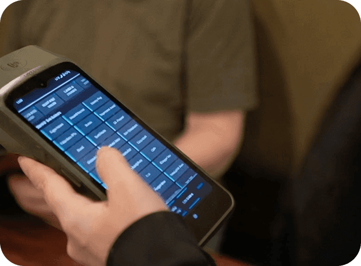 A SpotOn Handheld being used to enter an order at a table at J.P. Fitzgerald’s