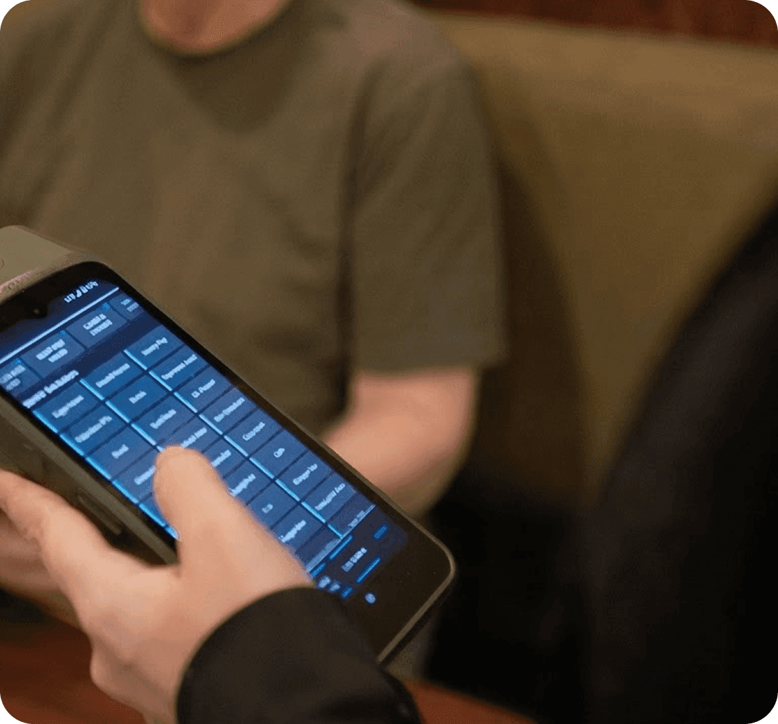 A SpotOn Handheld being used to enter an order at a table at J.P. Fitzgerald’s
