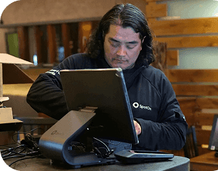 SpotOn technician sets up a POS terminal at a restaurant counter.