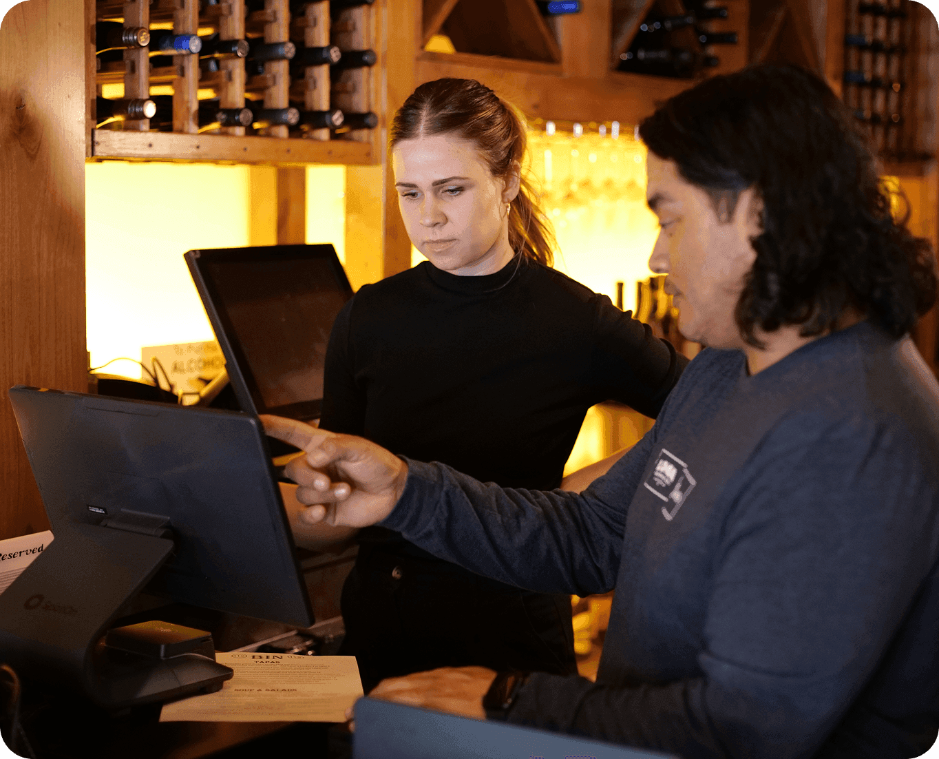 SpotOn representative installing a point-of-sale station and training a restaurant employee