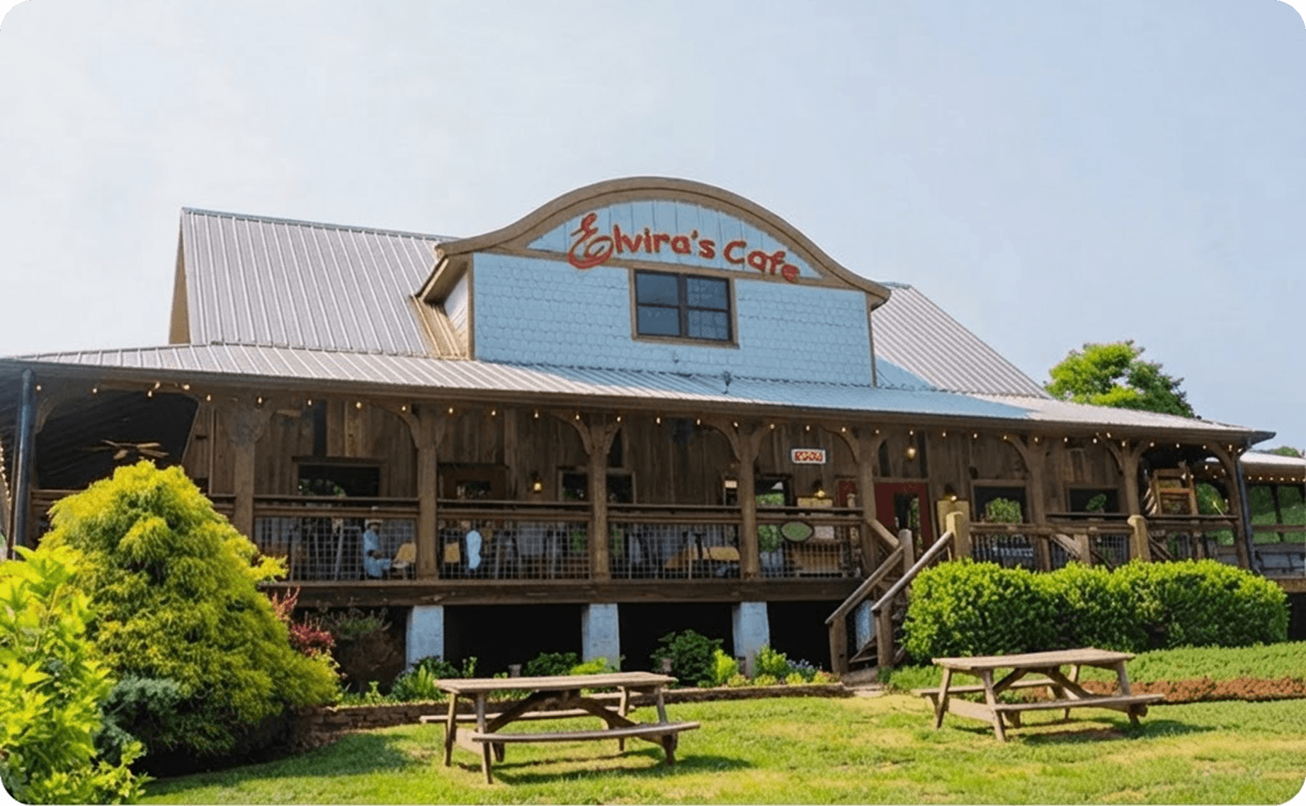 Exterior of Elvira’s Café, with a covered porch and picnic tables on the lawn