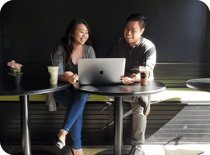 Kim Dieu, Owner of Mi ’N Tea, laughing with her brother Troy over a laptop