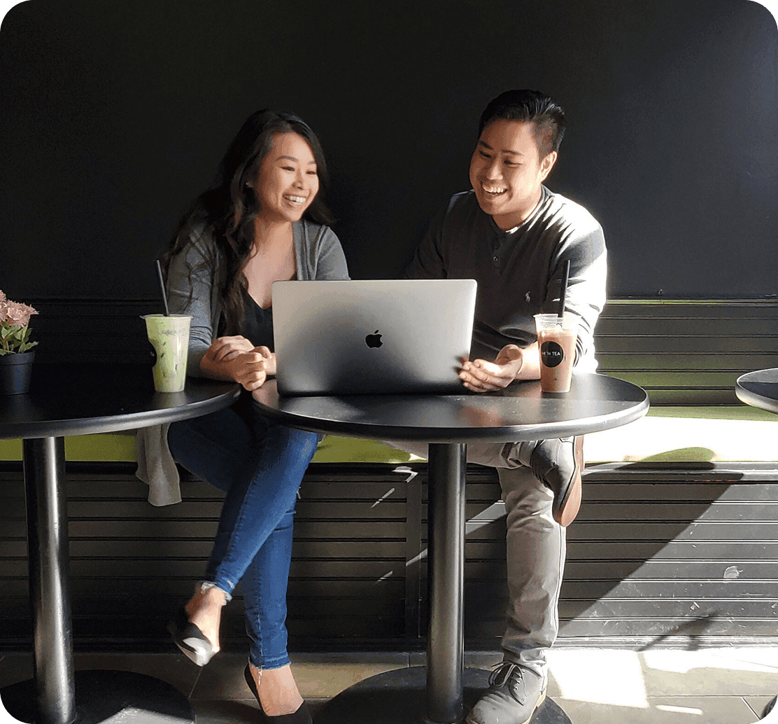 Kim Dieu, Owner of Mi ’N Tea, laughing with her brother Troy over a laptop
