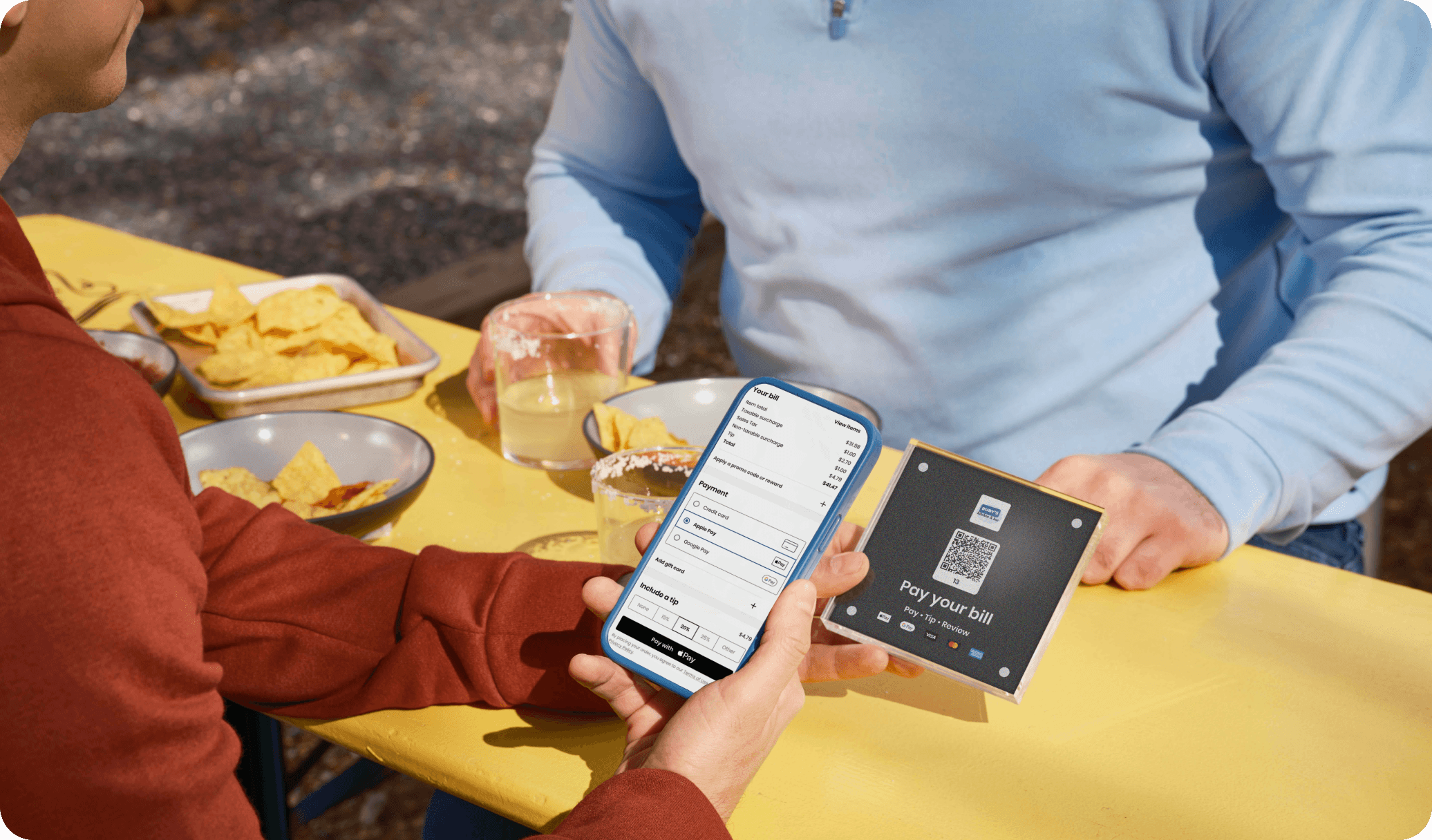 Guest at a restaurant scanning a QR code at the table to pay the check