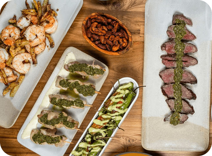 Overhead view of a Mediterranean small plate spread on a wooden table.